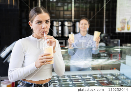 Young girl savoring taste of popular Taiwanese refreshing bubble tea Young girl savoring taste of popular Taiwanese refreshing bubble tea 139252044