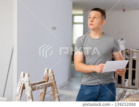 Young man checking project documentation in apartment during repair works 139252088