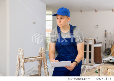 Teenage boy checking documents in construction site 139252123