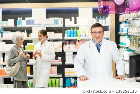 At pharmacy, man apothecary waiting for clients and invites with gesture go to chemist shop At pharmacy, man apothecary waiting for clients and invites with gesture go to chemist shop 139252130