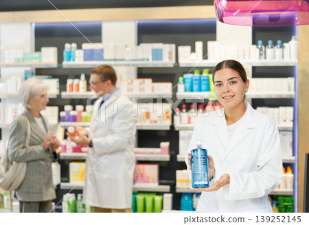 Female pharmacist in medical uniform posing with product intimate hygiene in her hands in pharmacy Female pharmacist in medical uniform posing with product intimate hygiene in her hands in pharmacy 139252145