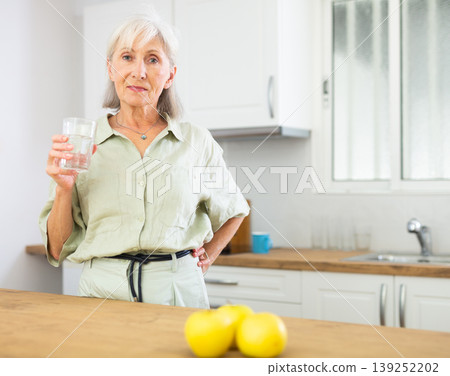 Smiling mature woman with glass of water 139252202