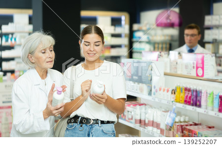 Young girl asking old female pharmacist for advice concerning intimate hygiene product Young girl asking old female pharmacist for advice concerning intimate hygiene product 139252207