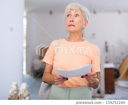 Mature woman checking completed construction work on drawing Mature woman checking completed construction work on drawing 139252284