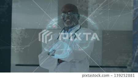 Standing senior doctor in lab coat projecting holographic brain in hall with stethoscope, overlay Standing senior doctor in lab coat projecting holographic brain in hall with stethoscope, overlay 139252881