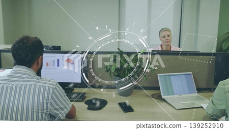 Displaying bar and pie charts on desktop monitor beside green potted plant on open-plan bench desk Displaying bar and pie charts on desktop monitor beside green potted plant on open-plan bench desk 139252910