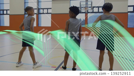 Standing three boys in athletic wear facing basketball hoop on court, with green ribbon graphic Standing three boys in athletic wear facing basketball hoop on court, with green ribbon graphic 139252911