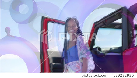 Exiting American woman walking from red SUV at shoreline, wearing sunglasses, with sea horizon Exiting American woman walking from red SUV at shoreline, wearing sunglasses, with sea horizon 139252930
