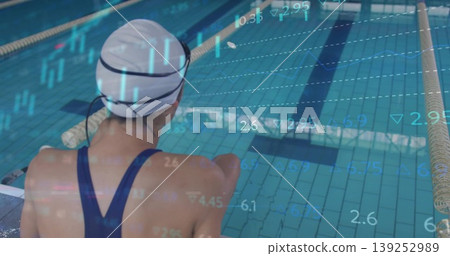 Viewing metrics, Asian swimmer sitting poolside by ropes in white swim cap and dark blue swimsuit Viewing metrics, Asian swimmer sitting poolside by ropes in white swim cap and dark blue swimsuit 139252989