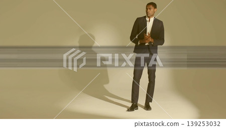 Standing black man in studio wearing tailored dark suit with white shirt, dress shoes, copy space Standing black man in studio wearing tailored dark suit with white shirt, dress shoes, copy space 139253032