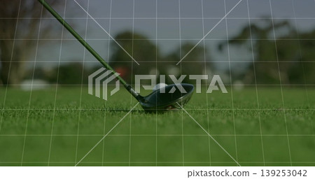 Positioning golf driver head behind golf ball on fairway turf, with tree-lined background Positioning golf driver head behind golf ball on fairway turf, with tree-lined background 139253042