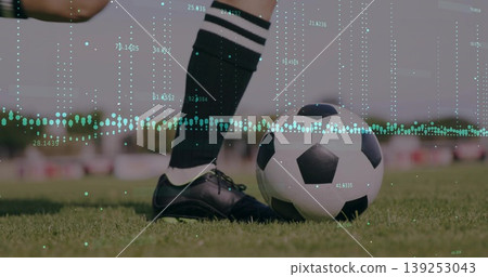 Showing player's legs wearing socks and cleats beside soccer ball on grass pitch, with data overlay Showing player's legs wearing socks and cleats beside soccer ball on grass pitch, with data overlay 139253043