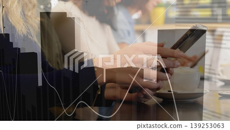 Holding smartphone between hands over wooden cafe table with cup, showing colleagues analyzing data 139253063
