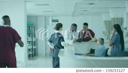 Gathering six healthcare workers reviewing charts at nurse station, with tablet and monitors Gathering six healthcare workers reviewing charts at nurse station, with tablet and monitors 139253127