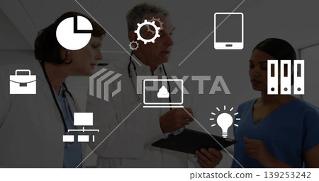Medical team reviewing data on tablet clipboard in hospital corridor, with stethoscopes data icons 139253242