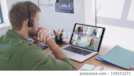 Conducting conference call on laptop while wearing headset at home desk, collaborating Conducting conference call on laptop while wearing headset at home desk, collaborating 139253271