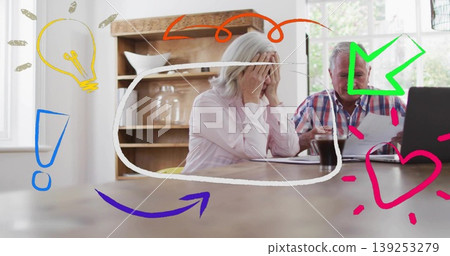 Sitting couple examining printed documents in kitchen with laptop, coffee mug and doodle symbols 139253279