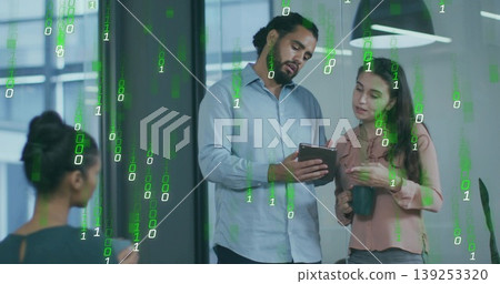 Collaborating office professionals examining tablet in workspace, with mugs and green binary code Collaborating office professionals examining tablet in workspace, with mugs and green binary code 139253320