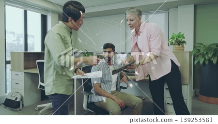 Collaborating office team reviewing document and tablet in modern open-plan office, data overlay Collaborating office team reviewing document and tablet in modern open-plan office, data overlay 139253581