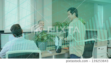 Holding virtual reality headset, standing colleague sharing idea in modern office with dual screens Holding virtual reality headset, standing colleague sharing idea in modern office with dual screens 139253643