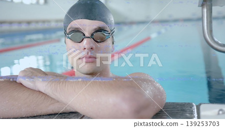 Leaning adult swimmer on pool deck wearing swim cap and goggles, with lane dividers and ladder Leaning adult swimmer on pool deck wearing swim cap and goggles, with lane dividers and ladder 139253703