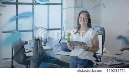 Smiling businesswoman wearing white blouse holding tablet in office, with digital overlays Smiling businesswoman wearing white blouse holding tablet in office, with digital overlays 139253751