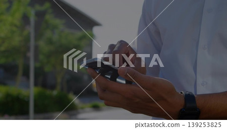Holding smartphone male checking messages and glancing at wristwatch on suburban road, copy space Holding smartphone male checking messages and glancing at wristwatch on suburban road, copy space 139253825