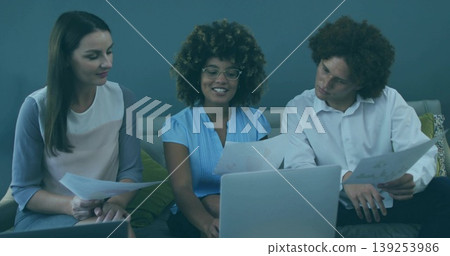 Discussing team sharing printed documents and laptop on modern office lounge sofa, with cushions Discussing team sharing printed documents and laptop on modern office lounge sofa, with cushions 139253986