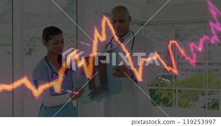 Doctor and nurse wearing attire reviewing radiograph and smartphone in exam room, with ECG graph Doctor and nurse wearing attire reviewing radiograph and smartphone in exam room, with ECG graph 139253997