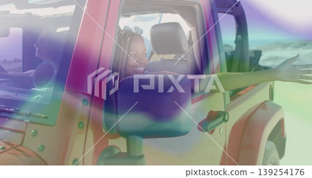 Leaning woman in summer clothes extending arm from red SUV window at sandy beach, with sunglasses Leaning woman in summer clothes extending arm from red SUV window at sandy beach, with sunglasses 139254176