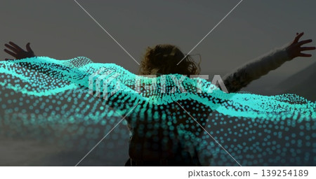 Raising arms female wearing patterned sweater on rocky shoreline, with turquoise dot wave overlay Raising arms female wearing patterned sweater on rocky shoreline, with turquoise dot wave overlay 139254189