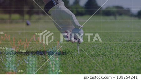 Placing golf ball on tee at golf course, with gloved hand wearing wristwatch and data overlay Placing golf ball on tee at golf course, with gloved hand wearing wristwatch and data overlay 139254241