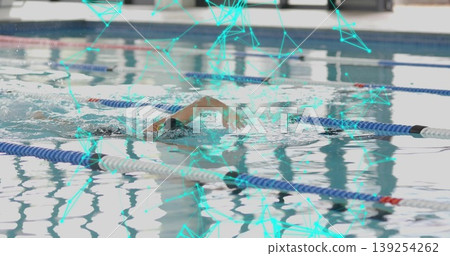 Gliding swimmer in cap goggles cutting through facility pool with teal network overlay lane ropes 139254262