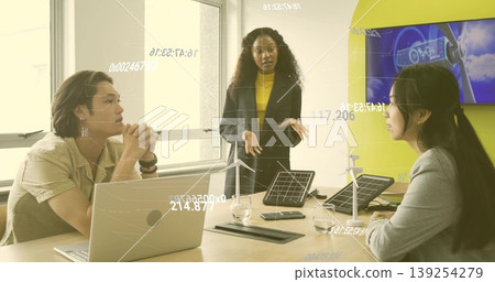 Presenting man in dark blazer leading meeting in conference room, with laptop and energy prototypes 139254279