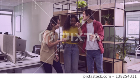 Discussing project using tablet by three colleagues in modern office with shelving, desks, monitors Discussing project using tablet by three colleagues in modern office with shelving, desks, monitors 139254311