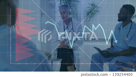 Taking notes senior female doctor using clipboard and pen in consultation room, with digital charts 139254405