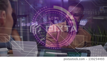 Smiling man in brown shirt listening to colleague at conference table, with holographic interface 139254493