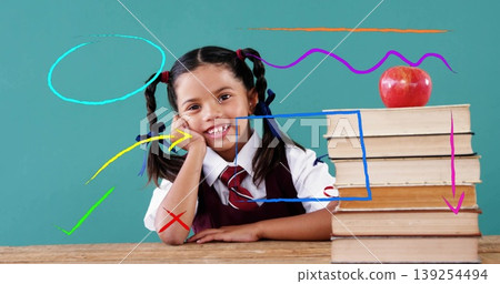 Schoolgirl in uniform leaning at wooden desk by teal chalkboard, with books, apple, digital doodles 139254494