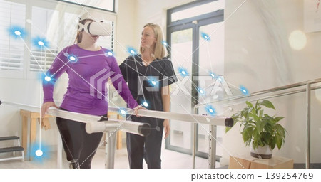Gripping bars patient wearing VR headset receiving therapist aid in rehab with network overlay Gripping bars patient wearing VR headset receiving therapist aid in rehab with network overlay 139254769