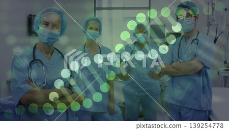 Standing medical professionals wearing blue scrubs and masks in hospital ward, with helix overlay Standing medical professionals wearing blue scrubs and masks in hospital ward, with helix overlay 139254778