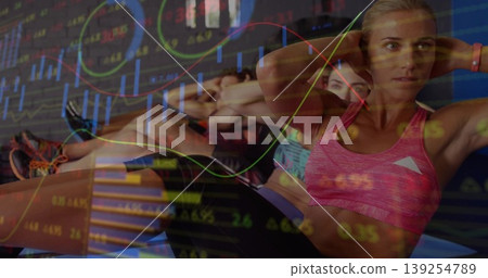Woman in pink sports bra crunching on exercise mat in gym, with stock charts, copy space Woman in pink sports bra crunching on exercise mat in gym, with stock charts, copy space 139254789