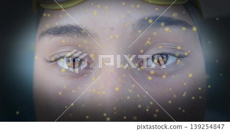 Showing female face with brown eyes and lashes in studio set, with sunglasses and glowing particles Showing female face with brown eyes and lashes in studio set, with sunglasses and glowing particles 139254847
