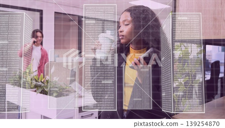Standing blazer-clad exec holding smartphone and stylus near glass wall holographic code in office Standing blazer-clad exec holding smartphone and stylus near glass wall holographic code in office 139254870