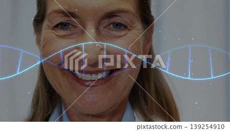 Smiling doctor wearing white lab coat over blue shirt in lab, featuring translucent blue DNA helix Smiling doctor wearing white lab coat over blue shirt in lab, featuring translucent blue DNA helix 139254910
