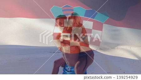 Giving piggyback ride couple wearing swim trunks, bikini on sandy beach, with Croatian flag overlay Giving piggyback ride couple wearing swim trunks, bikini on sandy beach, with Croatian flag overlay 139254929