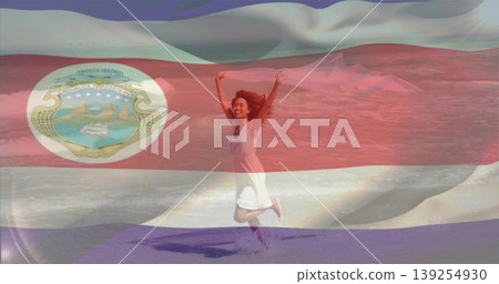 Jumping woman wearing white dress splashing sea water on sandy shore, with Costa Rican flag overlay Jumping woman wearing white dress splashing sea water on sandy shore, with Costa Rican flag overlay 139254930