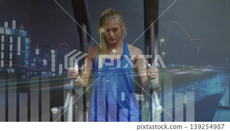 Woman in sportswear exercising on elliptical at gym, with candlestick charts and light trails Woman in sportswear exercising on elliptical at gym, with candlestick charts and light trails 139254987
