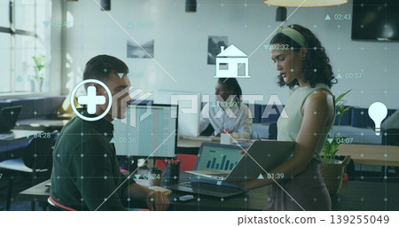 Holding laptop, office worker discussing data with coworker in open-plan office, digital icons Holding laptop, office worker discussing data with coworker in open-plan office, digital icons 139255049