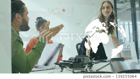 Team of four collaborating on strategy at conference table with drone and world map overlay Team of four collaborating on strategy at conference table with drone and world map overlay 139255064