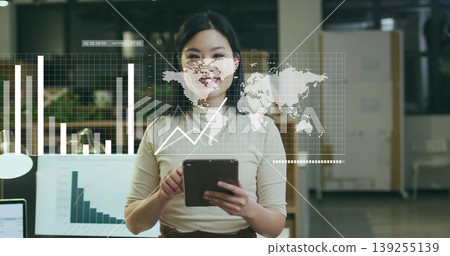 Data analyst woman wearing beige and brown outfit reviewing 3D charts at office desk, with tablet Data analyst woman wearing beige and brown outfit reviewing 3D charts at office desk, with tablet 139255139